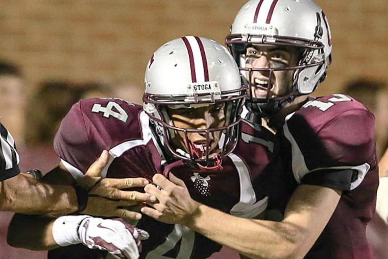 Conestoga's Martin Doesey (left) celebrates quarterback Tim Miller and
teammates after scoring a touchdown. (Steven M. Falk/Staff Photographer)