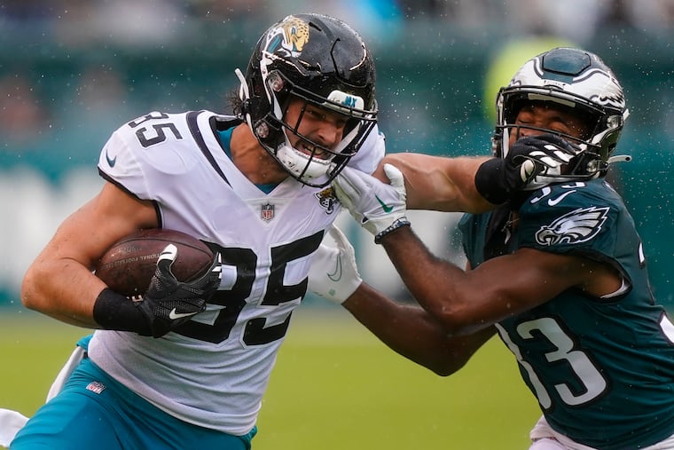 Jacksonville Jaguars' Dan Arnold, left, runs with the ball past Philadelphia Eagles' Josiah Scott during the first half of an NFL football game Sunday, Oct. 2, 2022, in Philadelphia.
