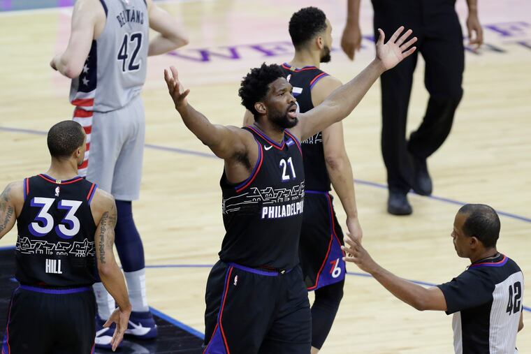 Sixers center Joel Embiid raises his arms after making a basket and for fouled against the Washington Wizards in the second quarter during game one of the Eastern Conference quarterfinals NBA playoffs on Sunday, May 23, 2021.