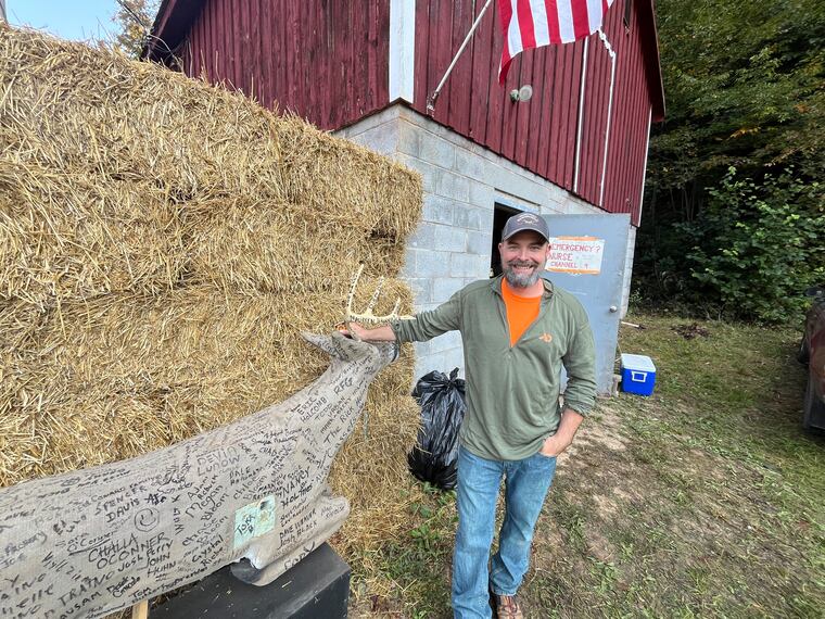 Phil Holcombe, president of the Pennsylvania Bowhunters Festival, stands beside a "running deer" his relatives created. Holcombe said it's been harder to get volunteers for the annual festival.