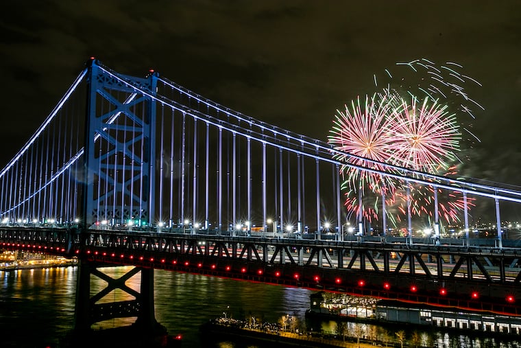 The fireworks over the Delaware River are viewed from the rooftop deck at the One Water Street apartment building and framed by the Benjamin Franklin Bridge on Dec. 31, 2024. This was the 6 PM fireworks geared for families.
