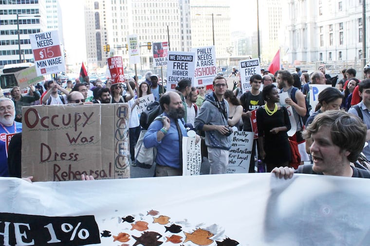 Protesters march down 15th Street as part of a May Day parade to protest income inequality in Center City, Philadelphia on Thursday, May 1, 2014. ( COURTNEY MARABELLA / Staff Photographer )
