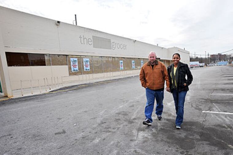 Jeff and Adrian Templeton of Germantown walk in the parking lot of their closed grocery store, Fresh Grocer, on Chelten Avenue. (Sharon Gekoski-Kimmel / Staff Photographer)