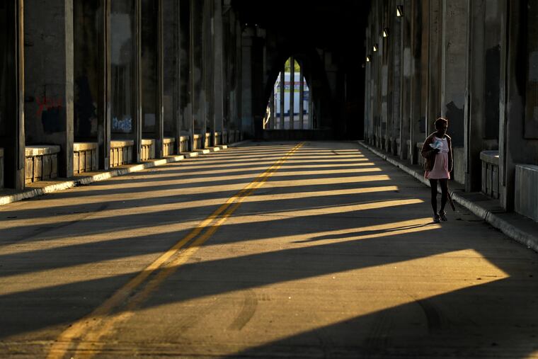 A woman walks along an empty street on Wednesday, May 6, 2020, in Kansas City, Mo.