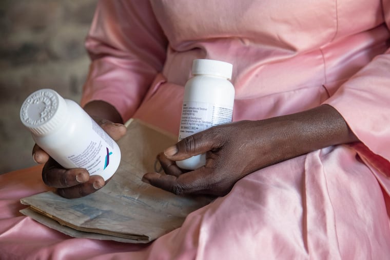 Florence Makumene holds HIV medication that she received through funding from the U.S. President's Emergency Plan for AIDS Relief (PEPFAR), along with her hospital records book, at her home in Harare, Zimbabwe, Feb. 7, 2025. The Trump administration has slashed funding for HIV prevention and treatment globally.