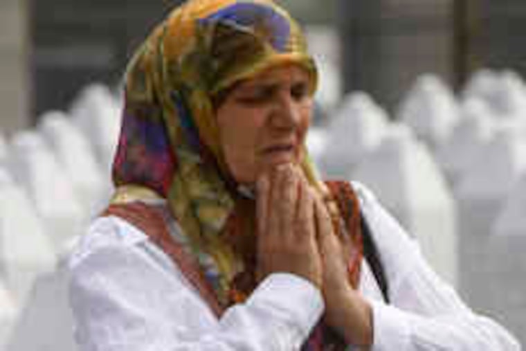 Hatidza Mehmedovic, who lost two sons and her husband to strife in her homeland, says a prayer at a memorial center near Srebenica.