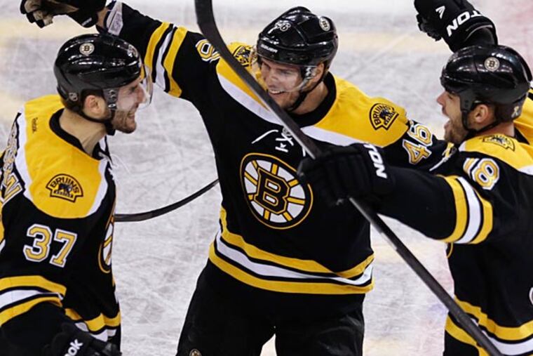 Bruins center Patrice Bergeron (37) rejoices with David Krejci (center) and Nathan Horton after his
goal in the final minute of the third period that tied it. (Charles Krupa / AP)