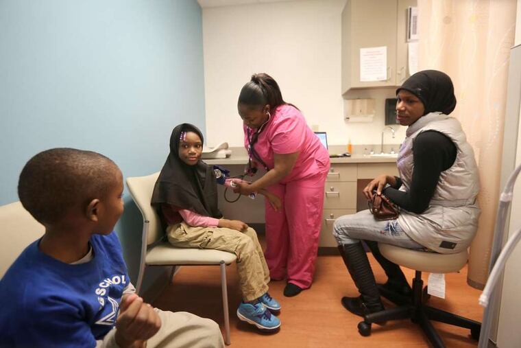 Kamaal Goodmond-Clark, 5, watches as medical assistant Tyesha Hightower, 27, takes the blood pressure of his sister Makyla-Zanabb, 9, with their mother, Yasmeen Goodmond, 27, in attendance at the Stephen Klein Wellness Center in North Philadelphia.