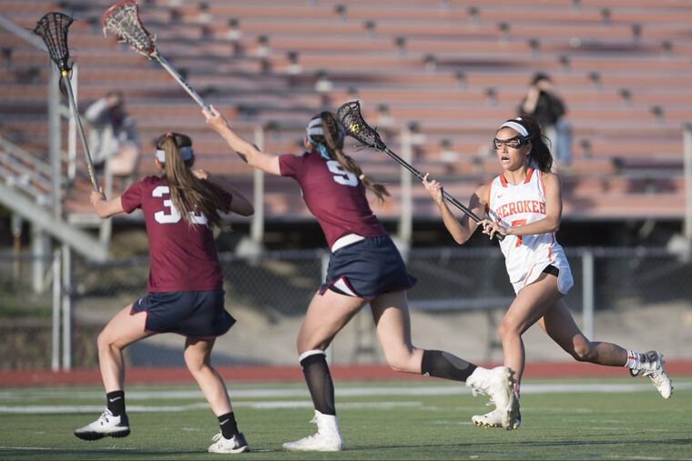 Cherokee’s Tori Hampton, right, 7, runs with the ball against Eastern defenders, Savannah Slack, 33, and Madison Cowdin , 9, during the first half of an 11-10 loss to Lenape Monday.