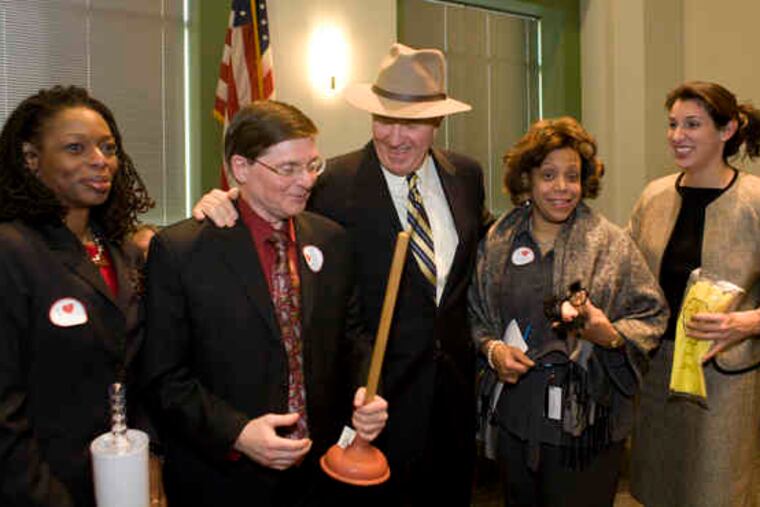 James P. Gallagher (center) with fellow Commissioners (from left) Sandra Dungee Glenn, Martin Bednarek, Denise McGregor Armbrister and Heidi Ramirez. The plunger referred to Gallagher's tendency to inspect school bathrooms.