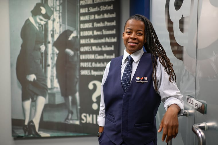 Keturah Johnson, international vice president for flight attendant union AFA-CWA, poses by a decades old poster with rules about uniforms and appearance for flight attendants, at the union's office Wednesday, Sept. 18, 2024, in Washington, D.C.