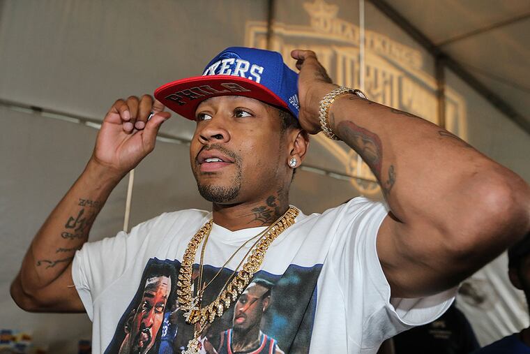 Former Sixer Allen Iverson tries on a Sixers hat in the VIP tent at a draft party on the Parkway on Thursday, June 23, 2016.