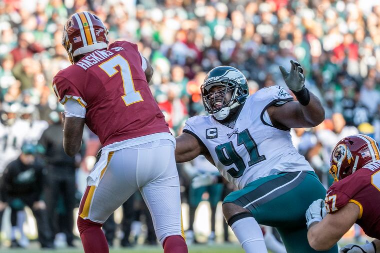 Eagles defensive tackle Fletcher Cox, right, does his best to pressure Washington quarterback, Dwayne Haskins, left, during the thrid quarter.