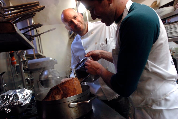 Marc Vetri (left) watches as sous chef Michael Solomonov pours some liquid into the brisket pot on the stove in the restaurant's kitchen as they prepare the Passover feast.