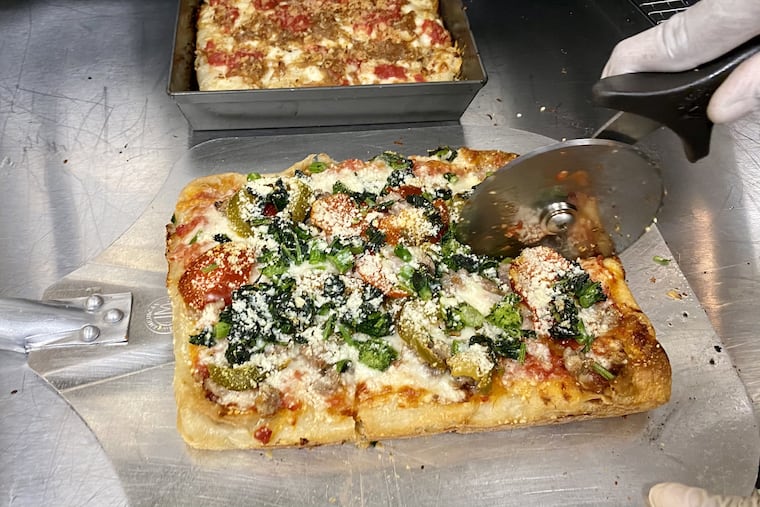 A pizza is cut up for a Benny Casanova's order. The pizza brand from chef Franklin Becker shares a kitchen in the city's Mantua section with a Middle Eastern concept called Shai.