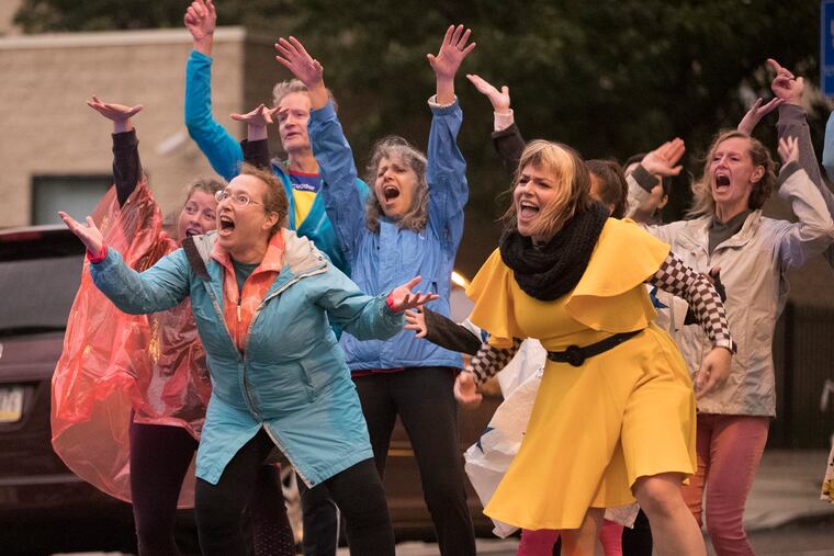 Dress rehearsal from Úumbal was in the rain, but it didn't keep the joy out of the dance. Dancing along Fifth Street are Ellen Dunkel (second from left), Liz Baldwin (second from right), and assistant director Sarah Gladwin Camp (right).