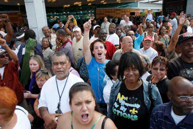 A crowd waiting for the SugarHouse Casino to open yesterday (above) chants for the anti-casino group to go home. Left: Players gather around one of the craps tables.