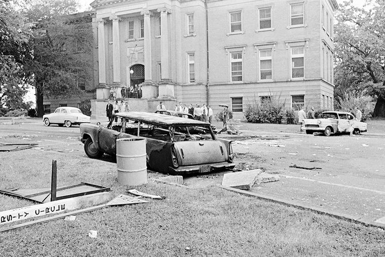 Burned cars at the University of Mississippi speak of the violence that erupted after the first black student enrolled in 1962, a time also captured in song by Bob Dylan. AP, File