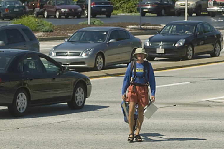 Marvin Vosseler, walking across the country to promote renewable energy, navigates Delaware County's busiest intersection at US Rt. One and 202. (Clem Murray/Inquirer)