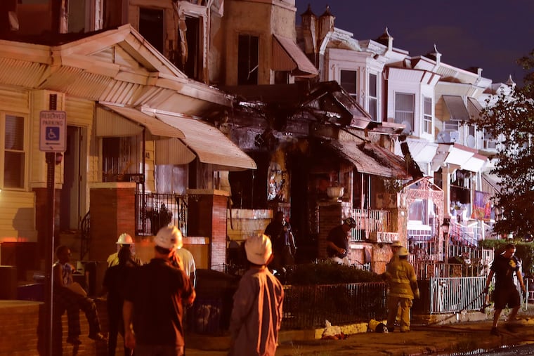 Philadelphia Fire fighters attend to a home on the 5800 block of Chestnut Street in West Philadelphia on Monday, August 2, 2021. Two people were found dead and two others were injured in a house fire that also damaged four neighboring homes.
