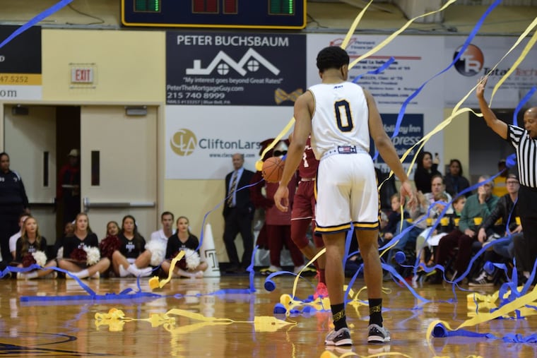 Redshirt junior guard Pookie Powell walks among the streamers thrown by La Salle fans onto the court in the first half of Sunday’s game against Temple at the Gola Arena.