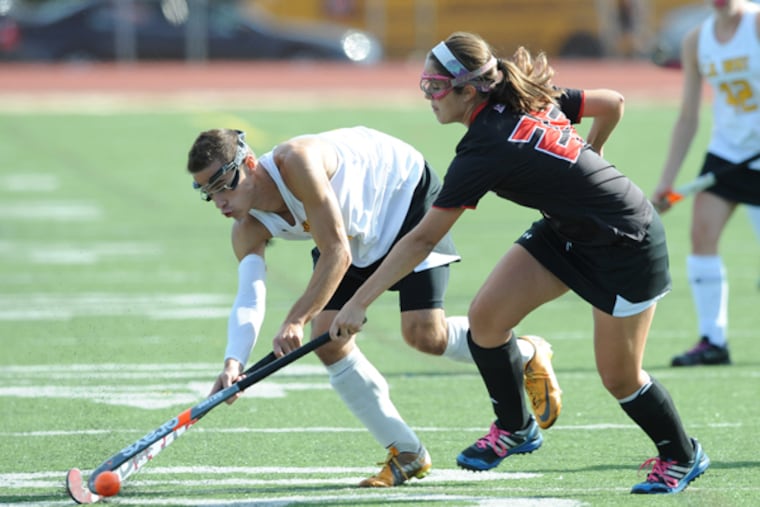 Central Bucks West senior Erik Fiorelli passes the ball to a teammate on the girls field hockey during a game against Hatboro Horsham High School Sept. 25, 2013. Fiorelli is allowed to play on the girls field hockey team because there is no boys field hockey team but hat rule is under review by the Pennsylvania Interscholastic Athletic Association, which may prohibit boys from playing on girls teams in the future. (CLEM MURRAY / Staff Photographer)