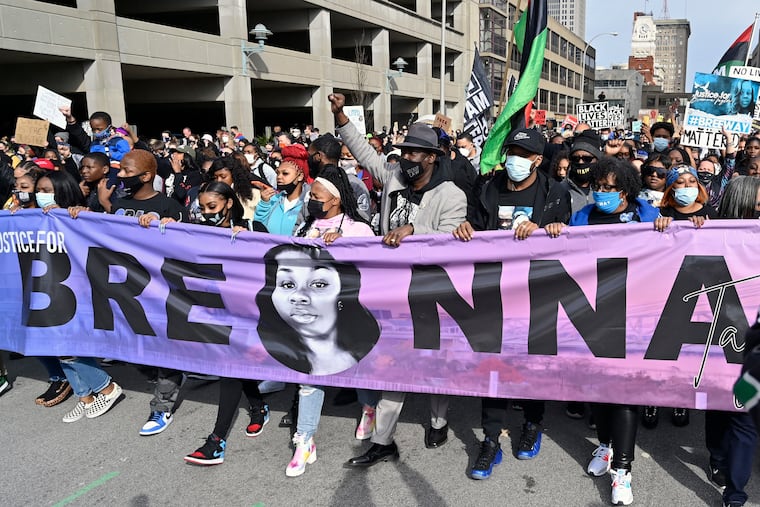 Tamika Palmer, center, the mother of Breonna Taylor, leads a march through the streets of downtown Louisville on the one year anniversary of her death in Louisville, Ky., Saturday, March 13, 2021. To her right is attorney Ben Crump.