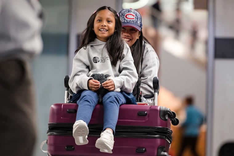 Vanessa Rodel and her 7-year-old daughter Keana exit Lester B. Pearson Airport in Toronto on Monday, March 25, 2019. The Filipino woman who helped shelter former NSA contractor Edward Snowden when he fled to Hong Kong has been granted refugee status in Canada. (Christopher Katsarov/The Canadian Press via AP)