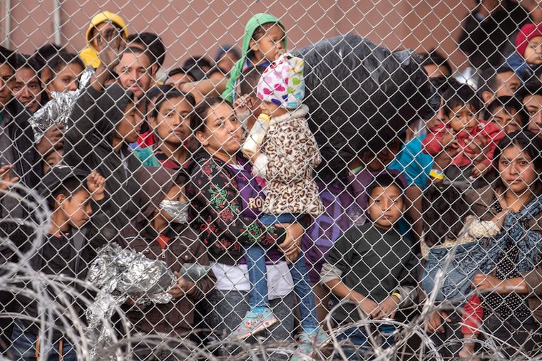 Migrants are gathered inside the fence of a makeshift detention center in El Paso, Texas, in 2019.