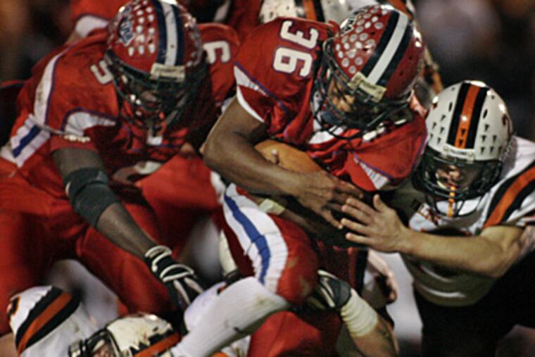 Neshaminy #36 Quilan Arnold eludes the grip of Pennsbury #60 Pat Cantrell (bottom left) but will get brought down by Pennsbury #25 Mike Ciotti (right) during the Pennsbury at Neshaminy H.S. football game on October 31. (Elizabeth Robertson / Inquirer)