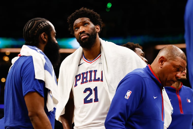 Joel Embiid (21) with James Harden and coach Doc Rivers commiserate late in the fourth quarter of a blowout Game 2 loss Wednesday in Boston.