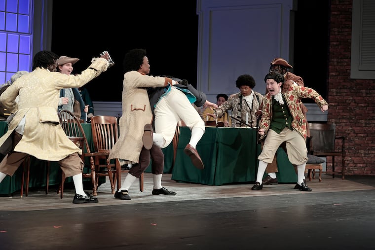 John Adams (played by Jackson Preisser, middle) and John Dickinson (played by Gregory Rist, right) are separated during a scene from the opening night of 1776: The Musical at the Philadelphia High School for Creative and Performing Arts on Wednesday, June 24, 2026.