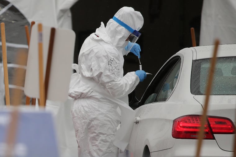 A medical worker uses a swab to check a driver at the coronavirus testing site for first responders and healthcare workers in the parking lot of the Rite Aid on the 7400 block of Ogontz Avenue in Philadelphia, PA on March 23, 2020.