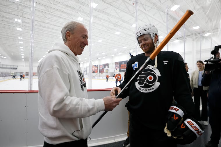Jack Brod and Flyers defenseman Cam York look at the stick York tossed into the crowd after the Flyers won Game 6 over the Pittsburgh Penguins on Wednesday night.