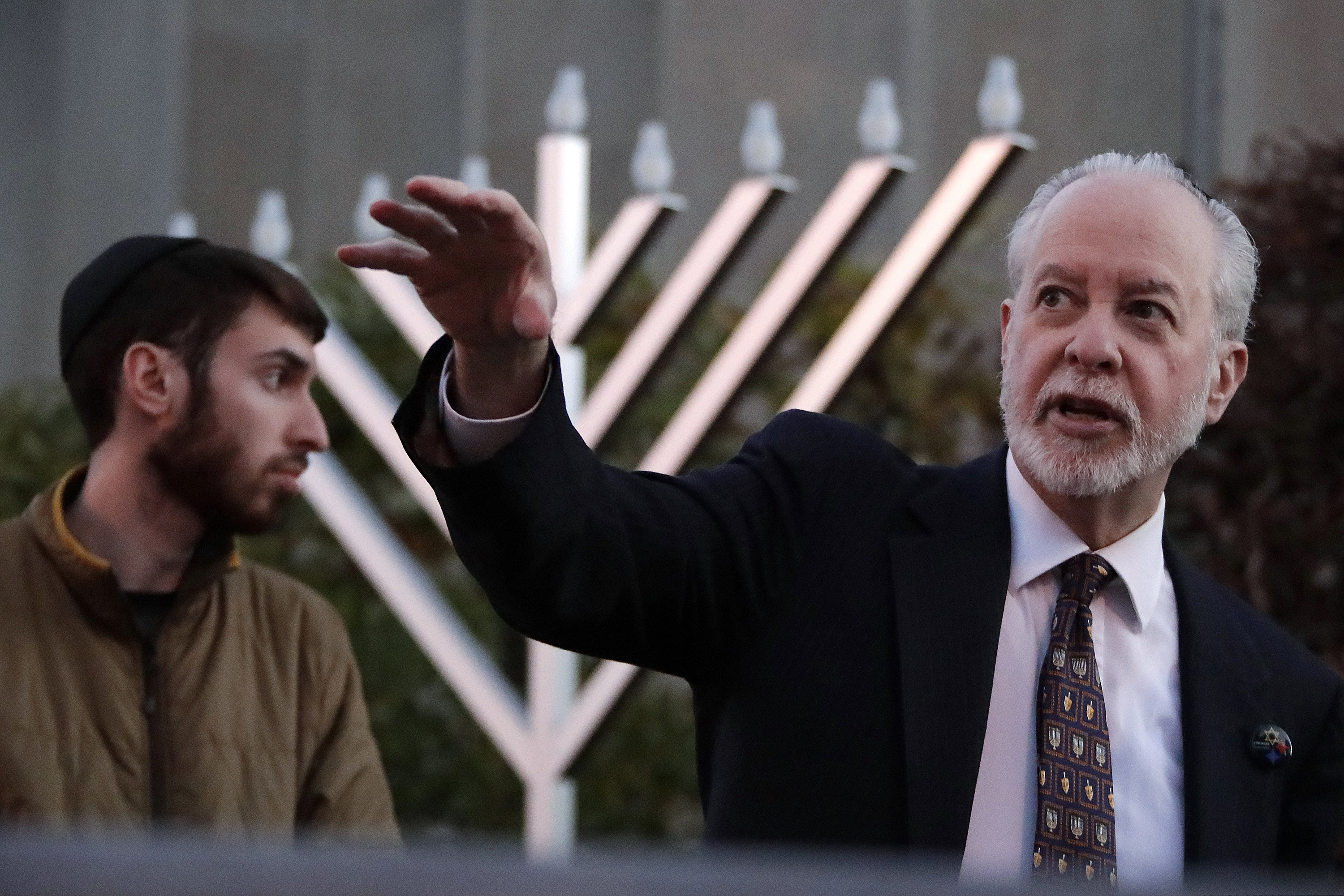 FILE - In this Dec. 2, 2018, file photo, Rabbi Jeffrey Myers, right and his son, Aaron, oversee the installation of a menorah outside the Tree of Life Synagogue before holding a celebration on the first night of Hanukkah in the Squirrel Hill neighborhood of Pittsburgh. As the Jewish community grieved in the aftermath of a deadly shooting at the Tree of Life Synagogue, Myers took a leading role during public memorials and presided over seven funerals in the space of less than a week. (AP Photo/Gene J. Puskar, File)