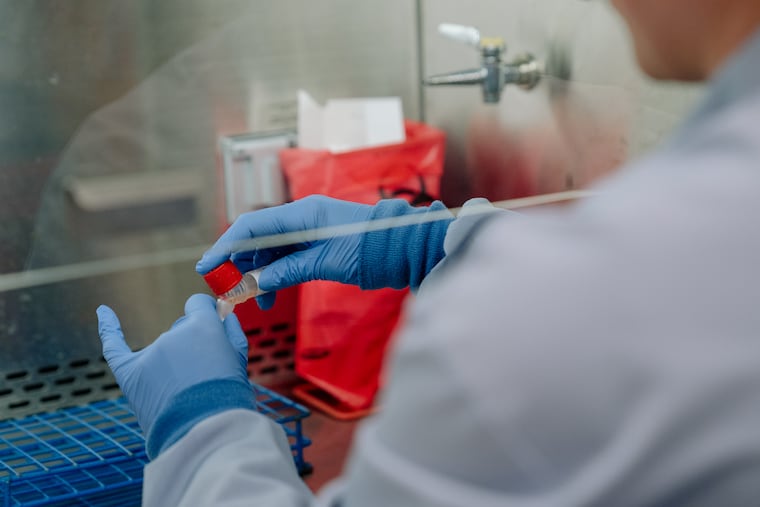 A technician transfers a coronavirus test sample to another tube for testing at the University of Washington Medicine Clinical Virology Laboratory in Seattle.