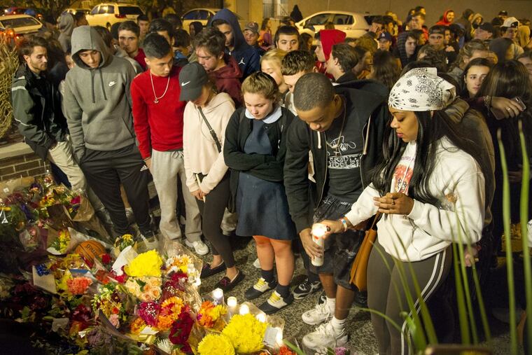 Grieving friends place flowers and candles at an impromptu memorial in South Philadelphia for Salvatore DiNubile. The St. Joseph’s Prep student was fatally shot in the neighborhood Tuesday night. A Mastery Charter School student, Caleer Miller, also was killed in the shooting, which police said Wednesday, Oct. 25, 2017, resulted from a dispute between two groups of teens.