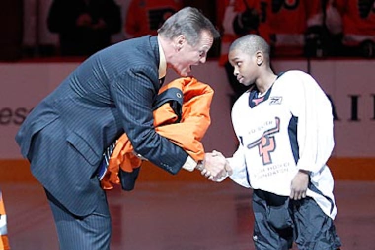 Former Flyer Bill Barber receives his banner from a member of the Ed Snider Youth Hockey Foundation. (Yong Kim/Staff Photographer)