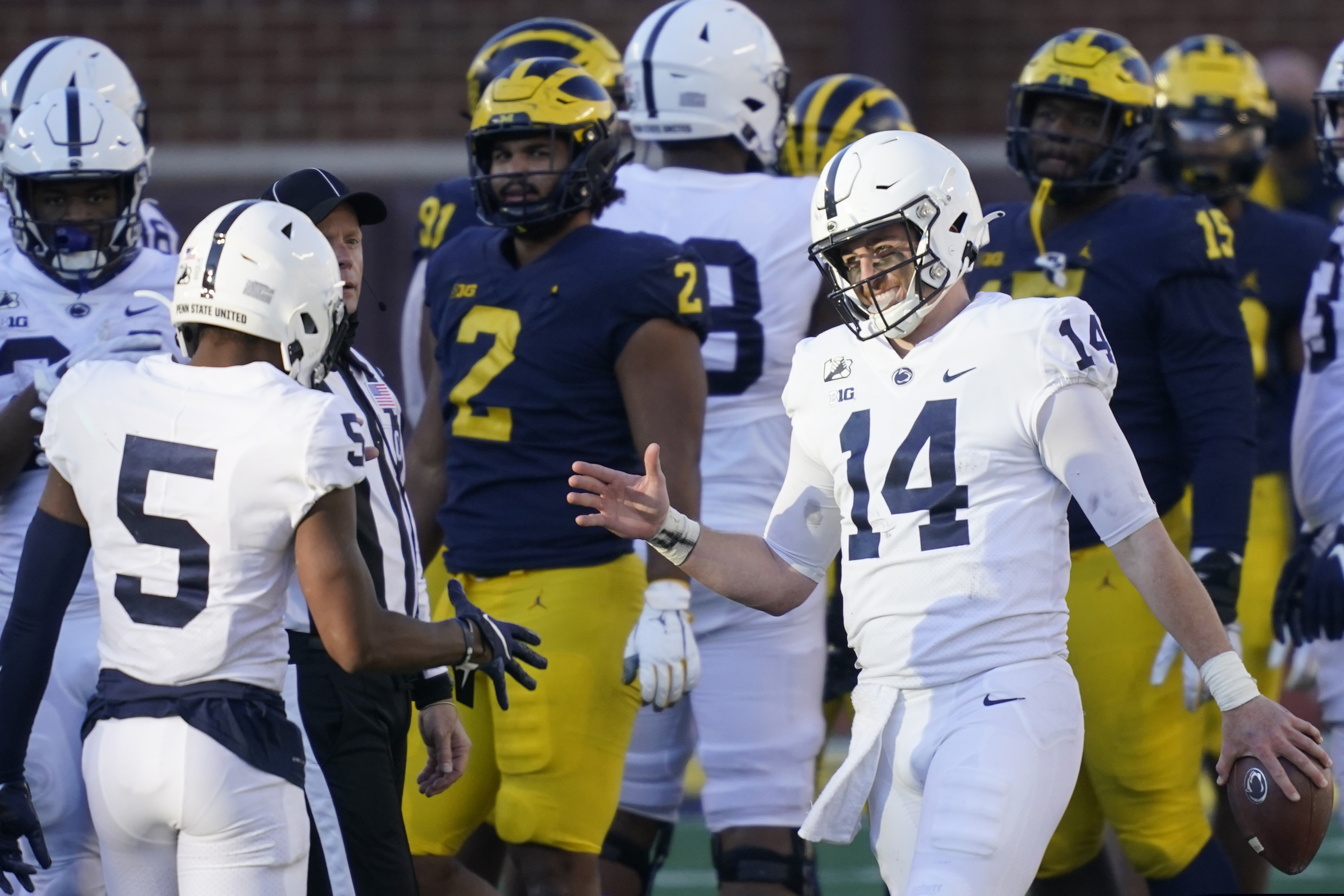 Penn State quarterback Sean Clifford (14) celebrates his team's win over Michigan with wide receiver Jahan Dotson on Nov. 28, 2020.