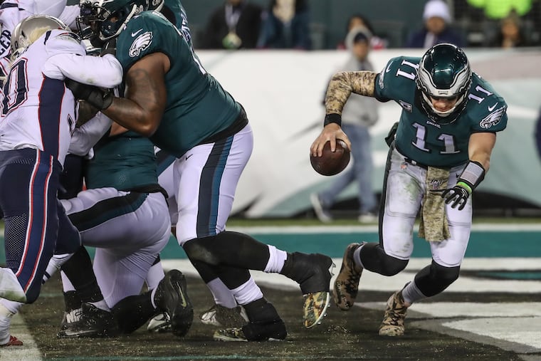Quarterback Carson Wentz stumbles away from the line on the final Eagles drive of the game against the New England Patriots.