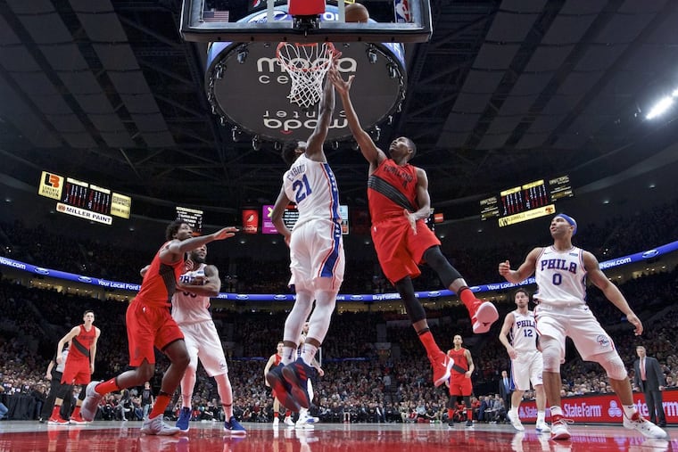 Joel Embiid, defending a shot by Trail Blazers forward Maurice Harkless, center right, during the first half Thursday night.