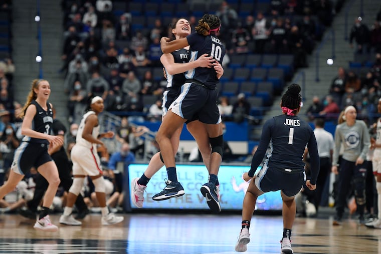 Villanova's Brianna Herlihy and Villanova's Christina Dalce (10) embrace in the air as they celebrate their team's win in an NCAA college basketball game against Connecticut, Wednesday, Feb. 9, 2022, in Hartford, Conn. (AP Photo/Jessica Hill)