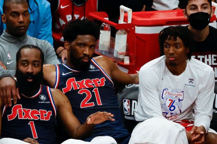 Sixers center Joel Embiid sits with Sixers guard James Harden and guard Tyrese Maxey at the end of game four of the first-round Eastern Conference playoffs against the Toronto Raptors on Saturday, April 23, 2022 in Toronto. The Raptors beat the Sixers 110-102.