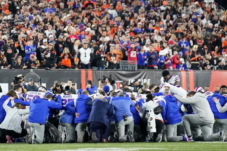 Buffalo Bills players and staff pray for safety Damar Hamlin after he went into cardiac arrest Monday during the game against the Bengals in Cincinnati.