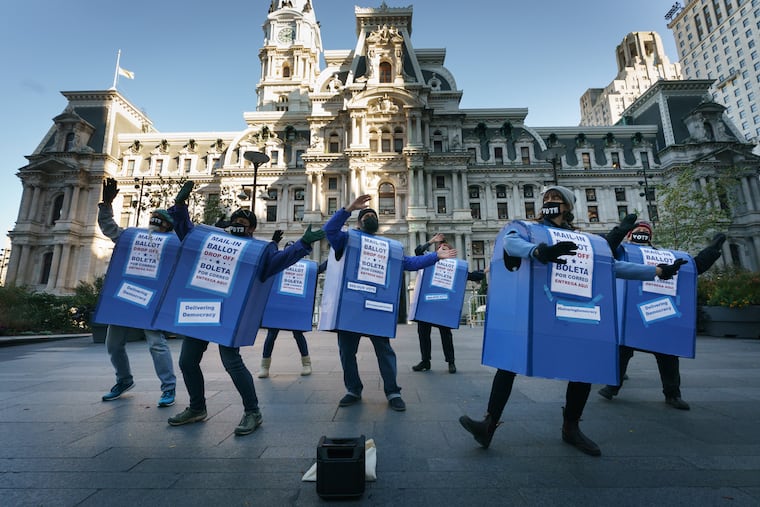 Performers from Delivering Democracy dressed as ballot boxes perform at City Hall in 2020.