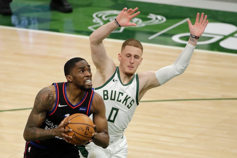 The 76ers' Shake Milton drives to the basket against the Milwaukee Bucks' Donte DiVincenzo.