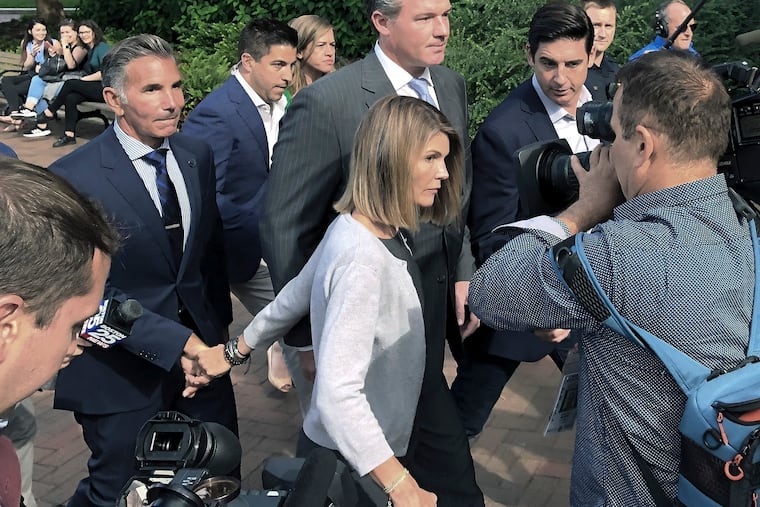 In this Aug. 27, 2019 photo, Lori Loughlin departs federal court with her husband, clothing designer Mossimo Giannulli, left, in Boston, after a hearing in a nationwide college admissions bribery scandal.