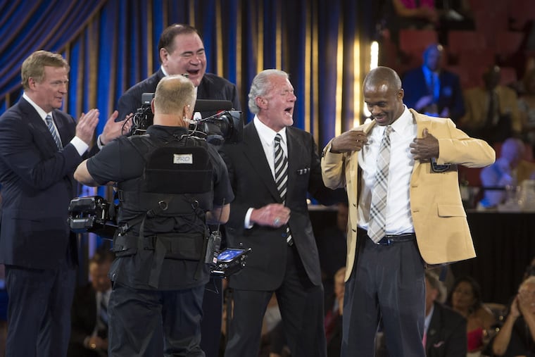 NFL Commissioner Roger Goodell, left, and David Baker, president of the Pro Football Hall of Fame, applaud as Marvin Harrison receives his gold jacket from presenter Jim Irsay at the Pro Football Hall of Fame enshrinees' dinner, Thursday, Aug. 4, 2016, in Canton, Ohio. (Bob Rossiter/The Canton Repository via AP)