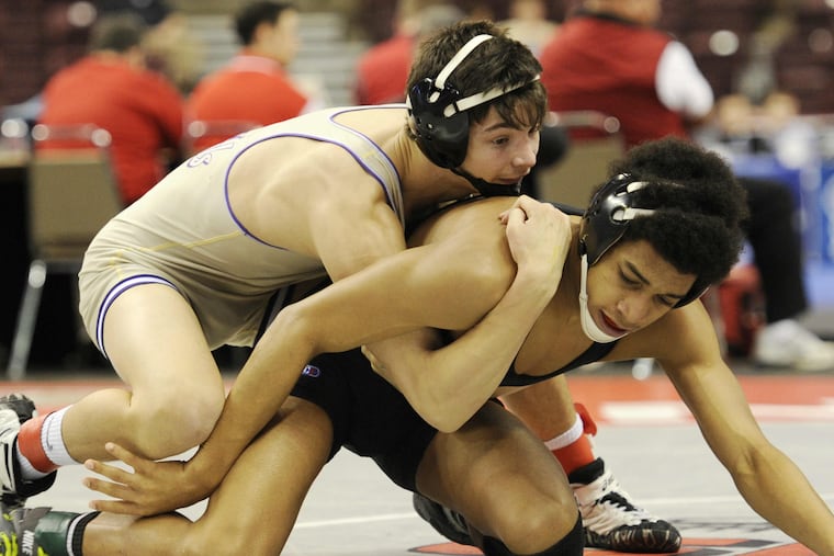 Upper Darby's Colin Cronin (left) wrestles Cathedral Prep's Carter Starocci in a 132-pound match in 2016. Upper Darby has a new attendance policy for wrestling and other winter sporting events due to safety concerns.