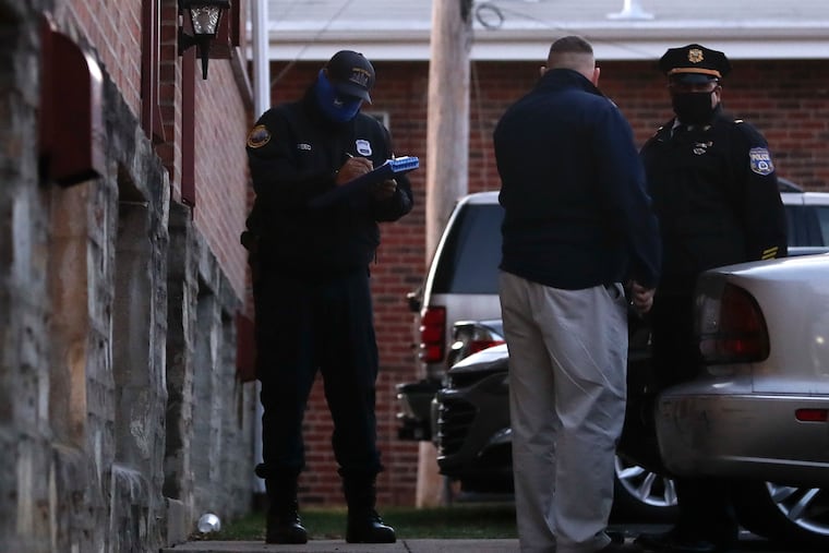 Philadelphia Police investigators stand outside the Michner Court Apartments in Northeast Philadelphia after the shootings Friday. A maintenance worker found a male and female with gun shots to the head.
